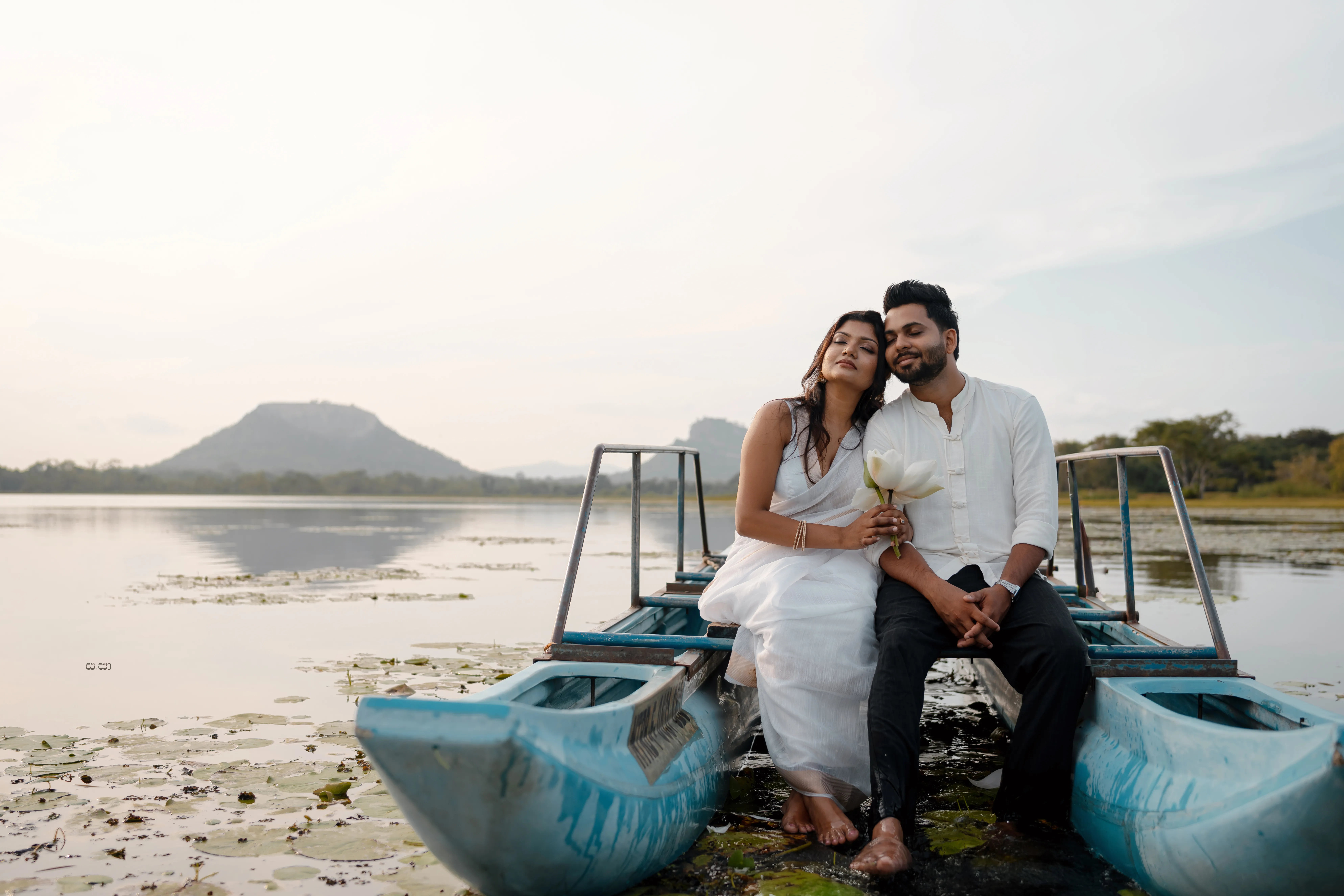 The couple shares a relaxed portrait aboard the weathered blue boat.