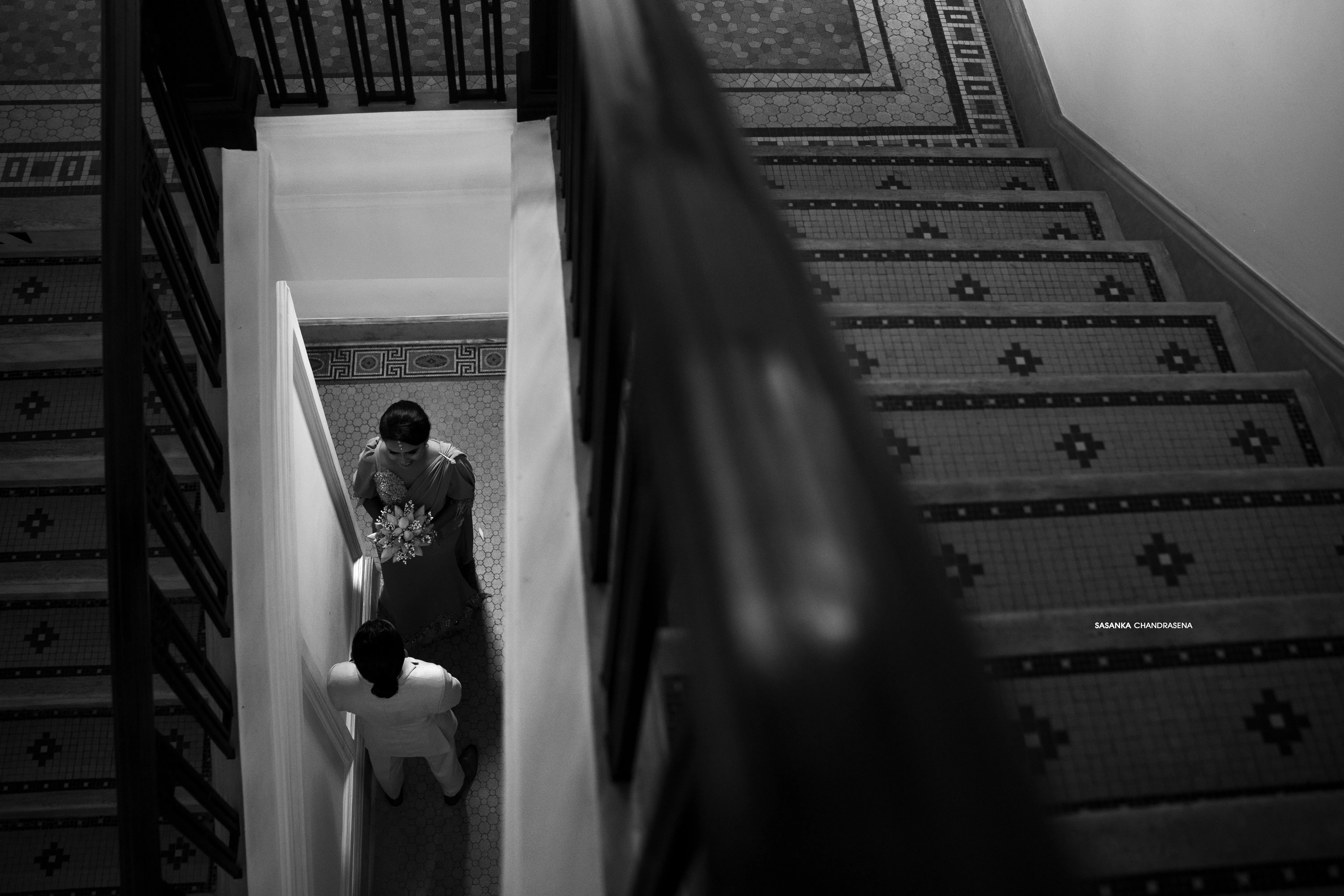 A black-and-white portrait places the couple on a patterned wooden staircase.