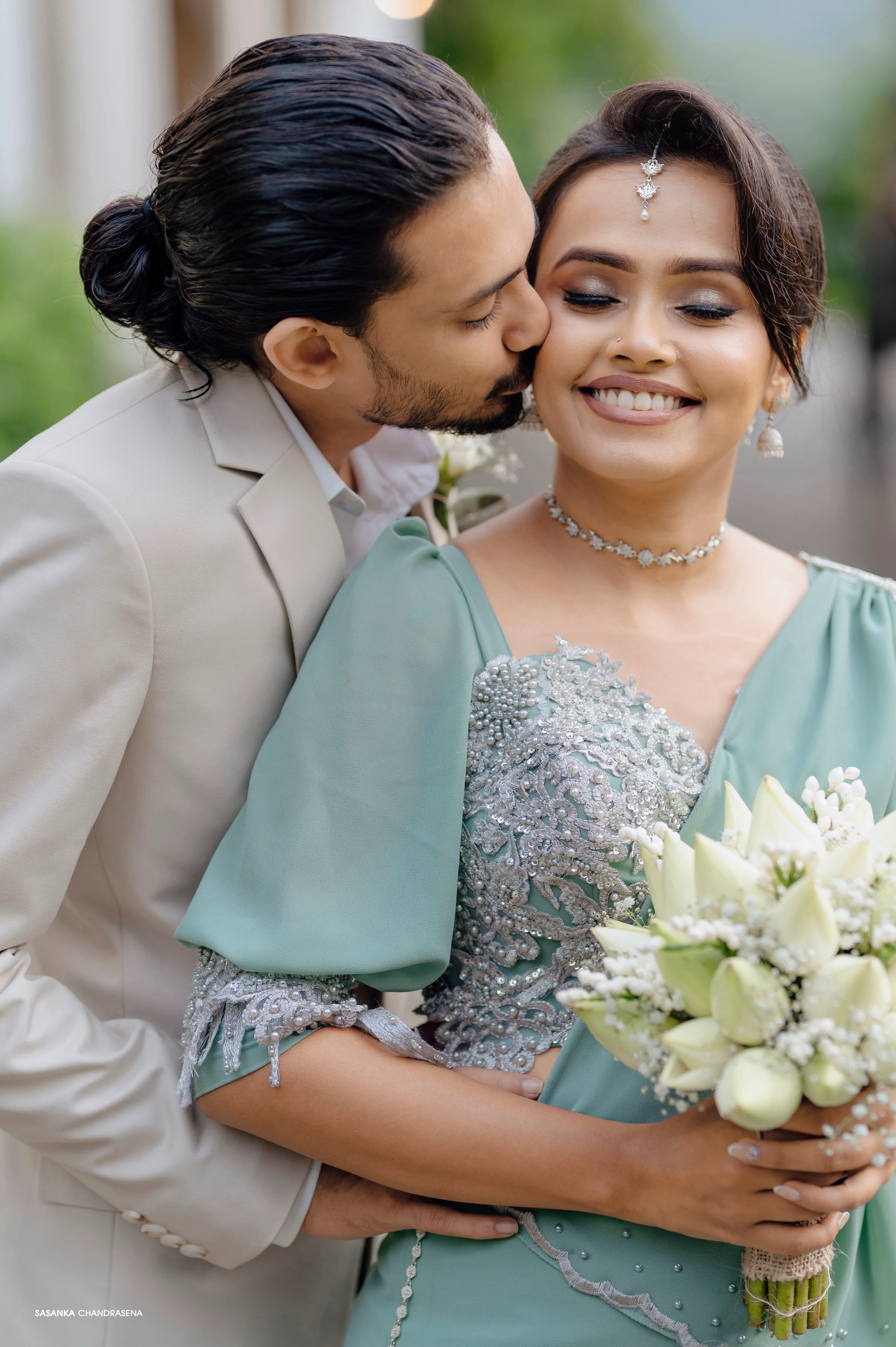 The groom-to-be kisses his partner during an intimate garden portrait.