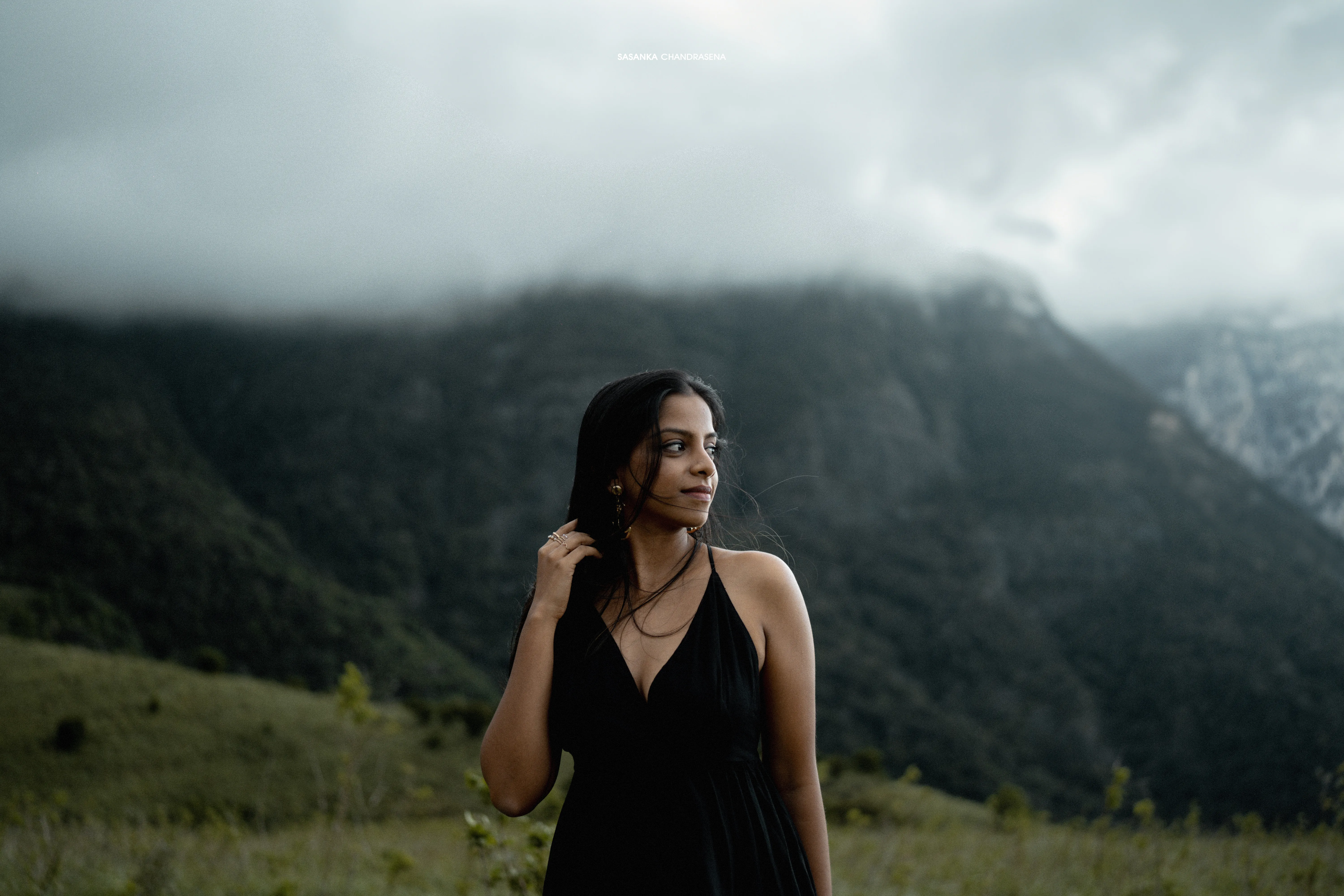 Vidushi stands alone in black against the mist-covered valley.