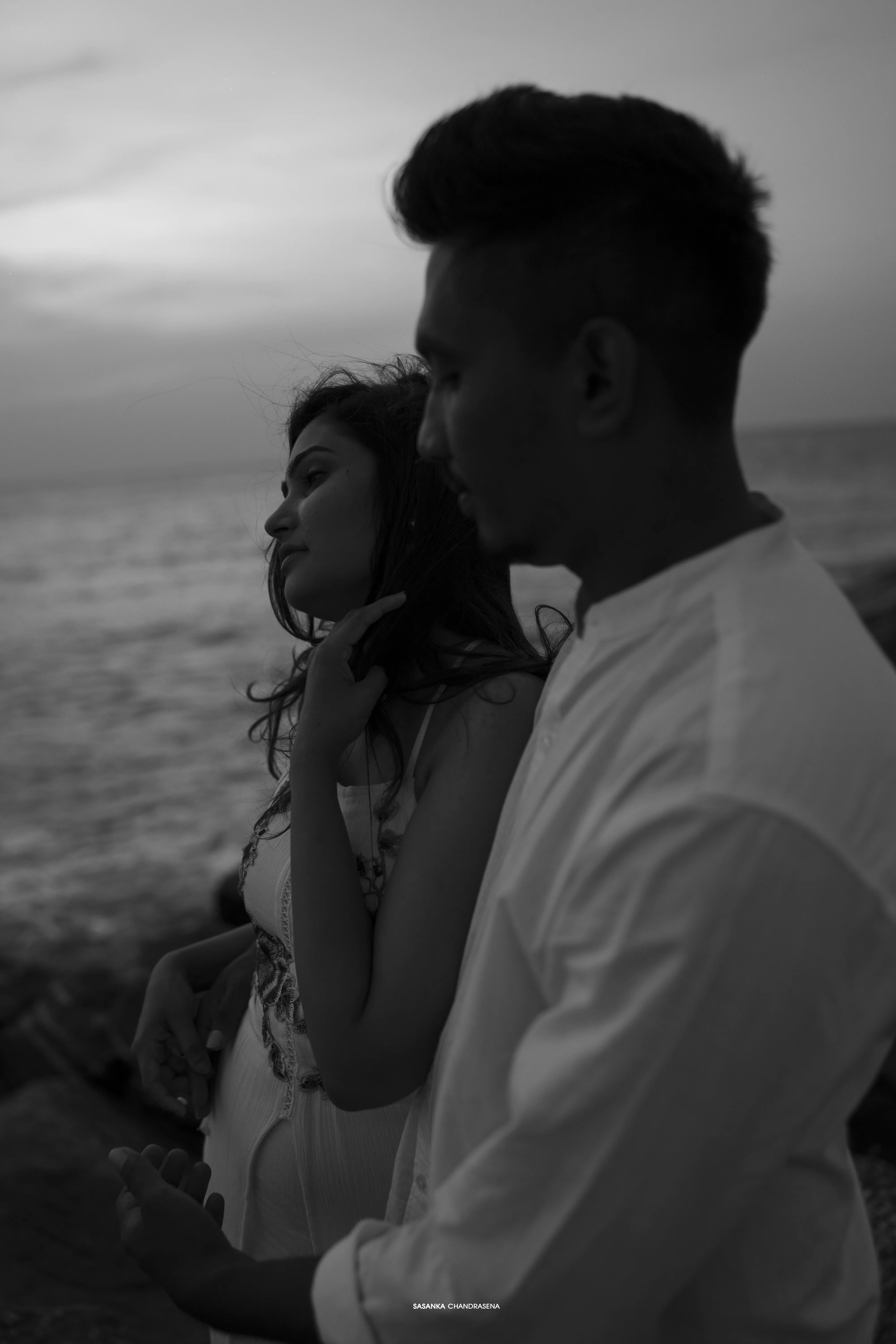 A black-and-white close-up layers the couple against a pale horizon.