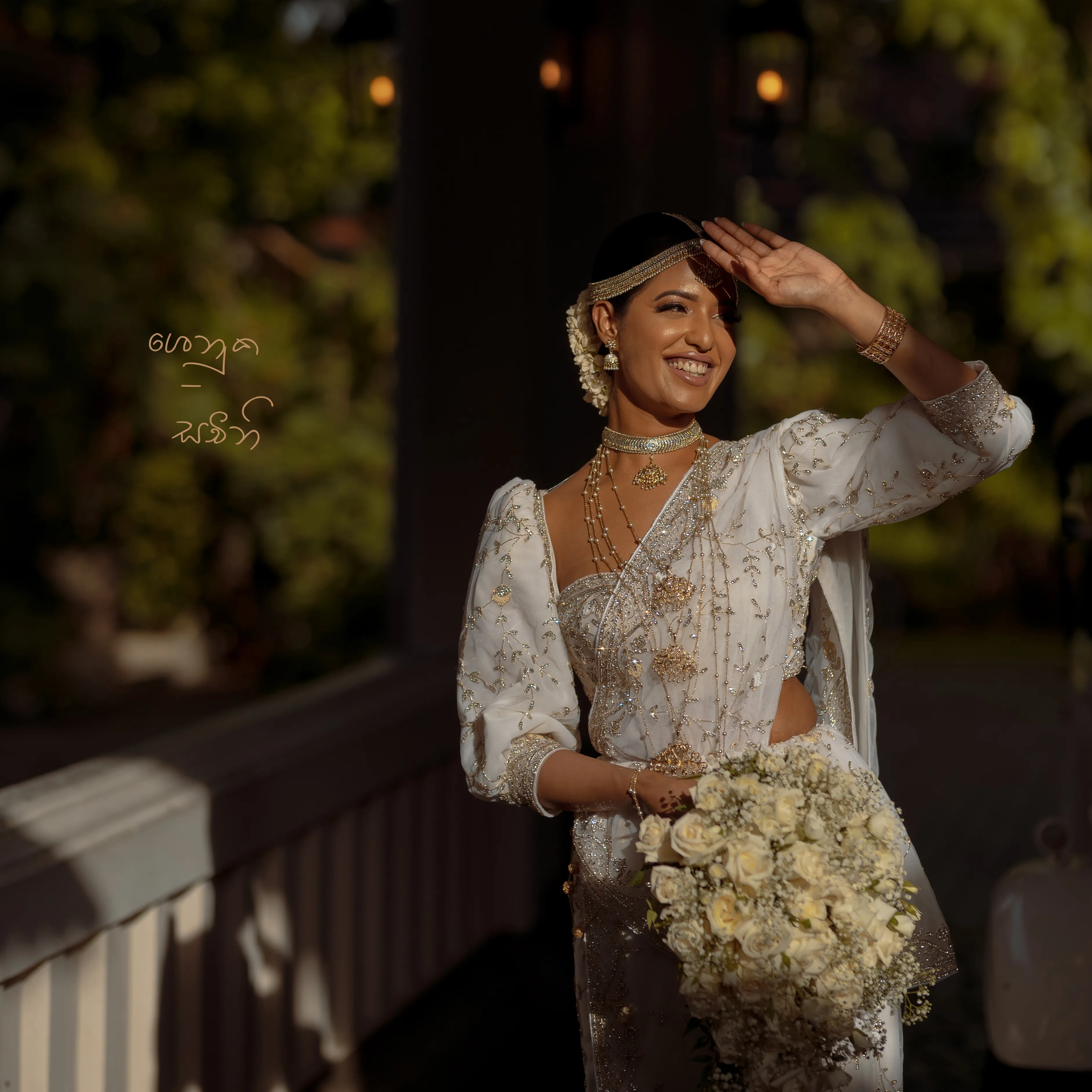 Sachini laughs with her bouquet on a softly lit wooden balcony.