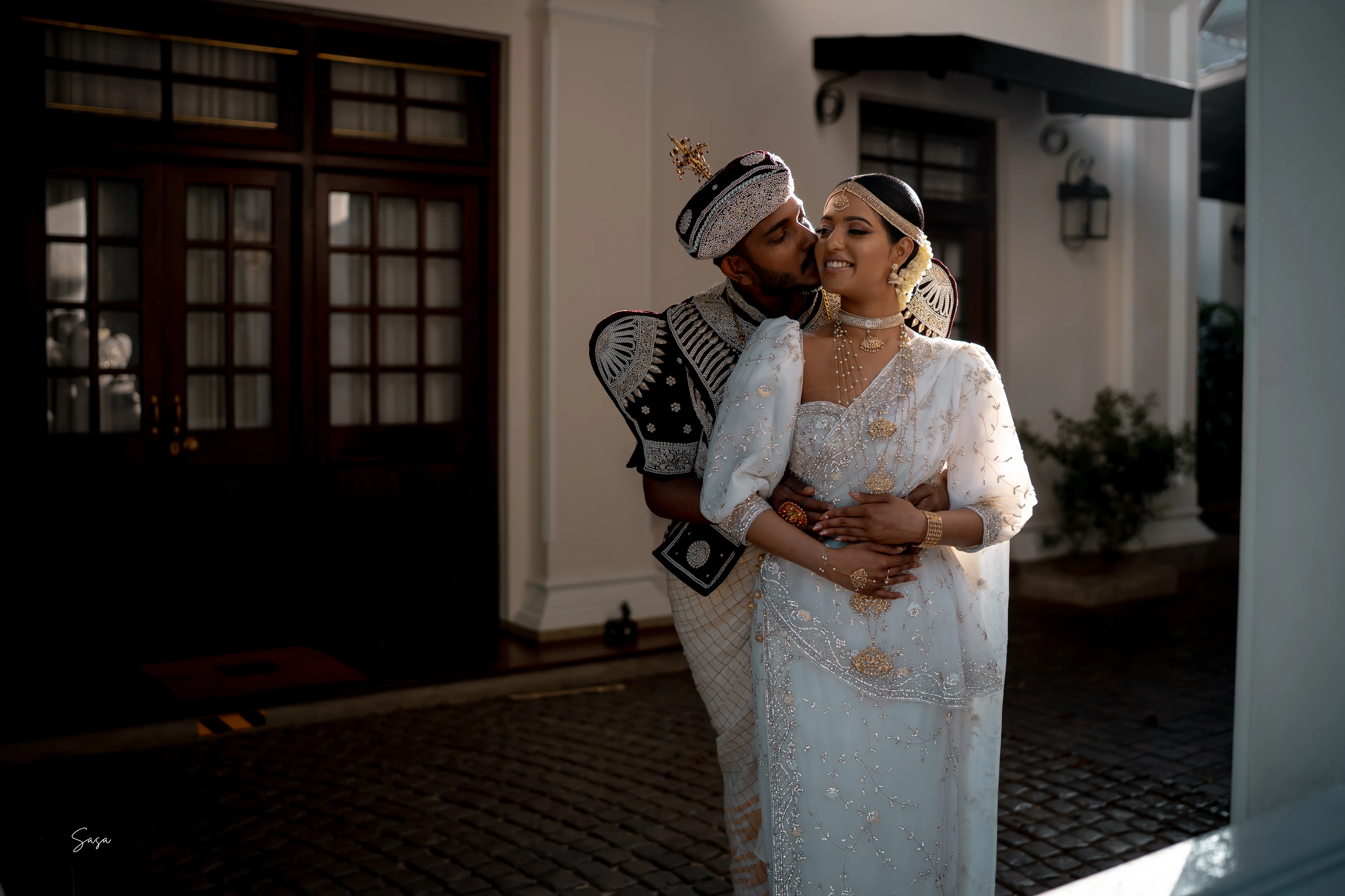 Shenuka leans close to Sachini outside the historic residence.