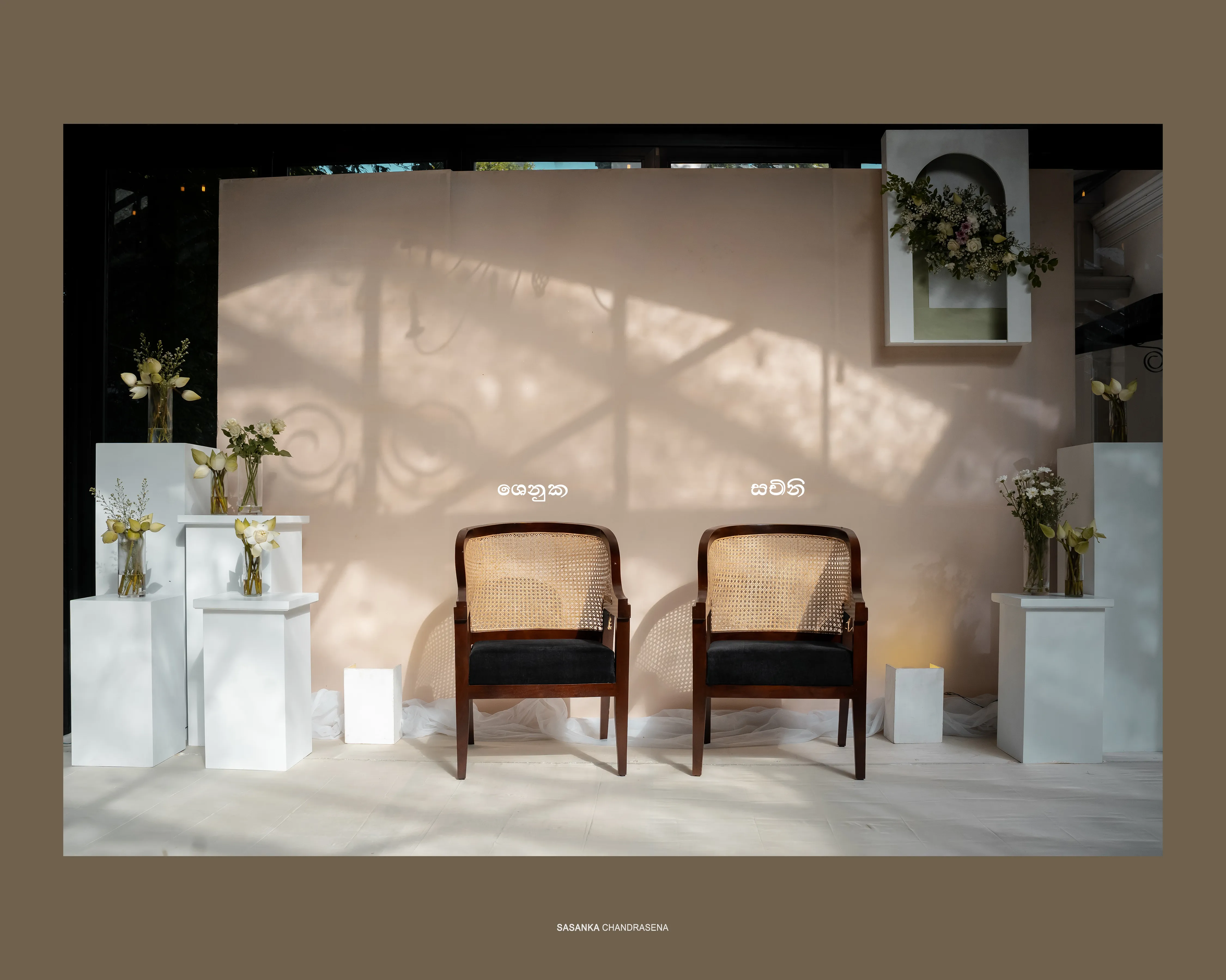 Two ceremonial chairs sit within a minimal white wedding setting.