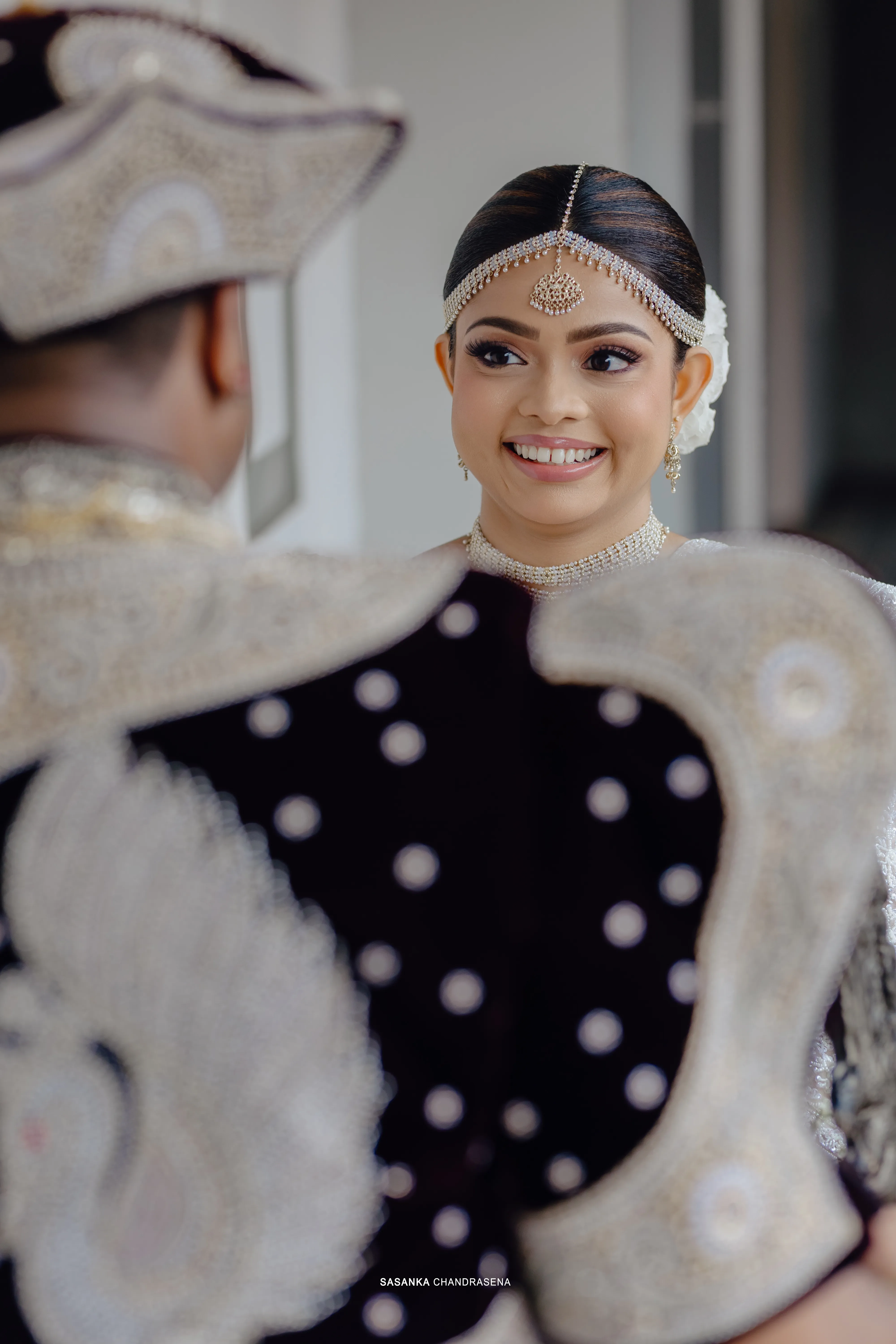 Tharu looks toward Chandula with a bright, relaxed smile.