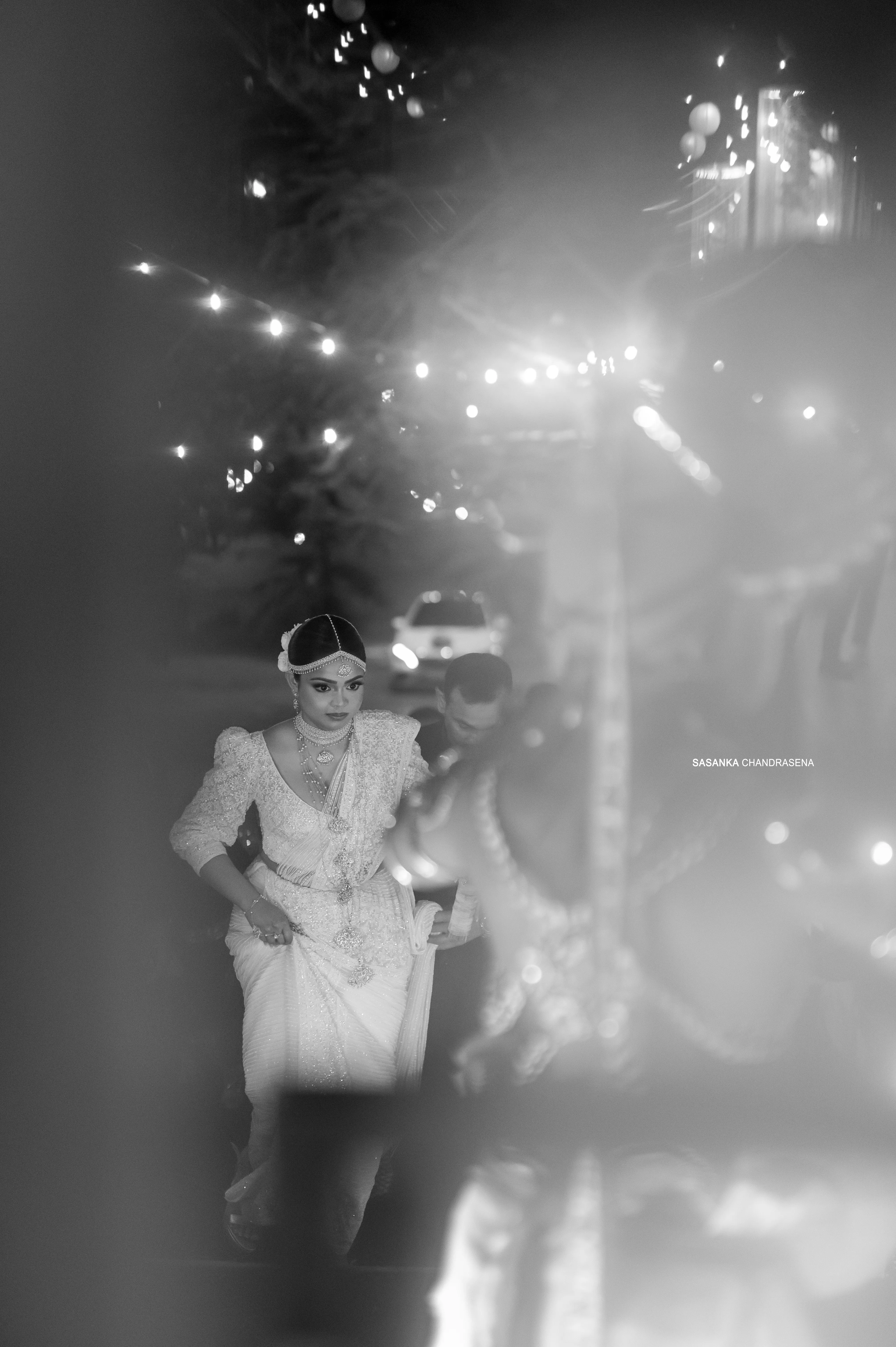 A soft black-and-white frame captures the couple moving together at the reception.