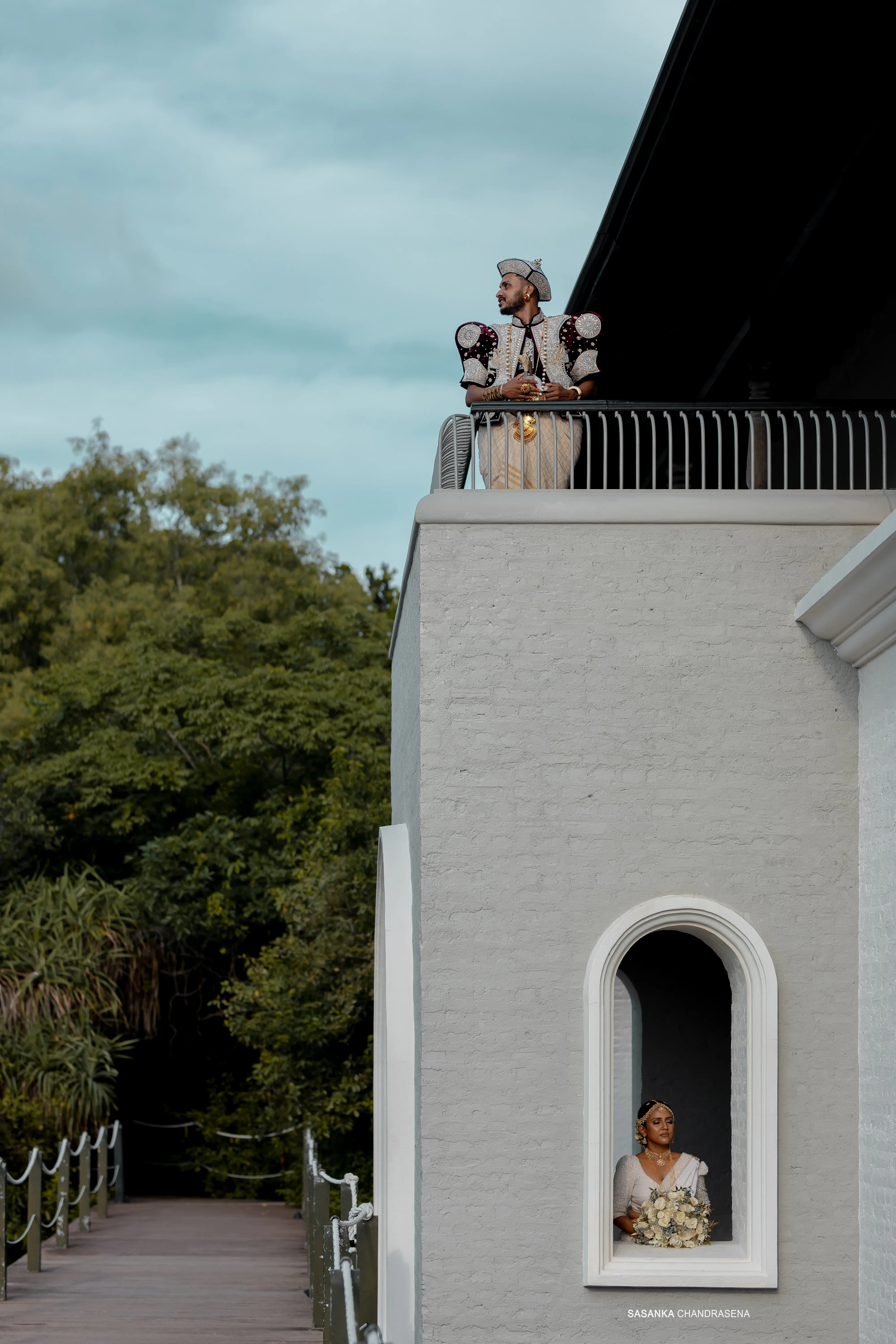 Malki is framed by a tall arched opening in the minimalist facade.